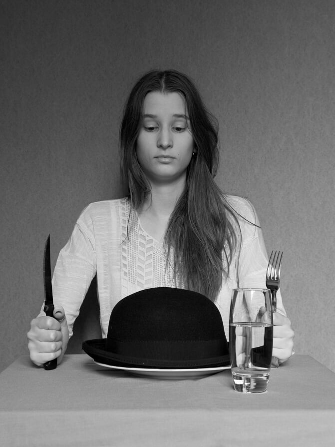 photographie de la photographe et webdesigneuse regardant son chapeau dans son assiette