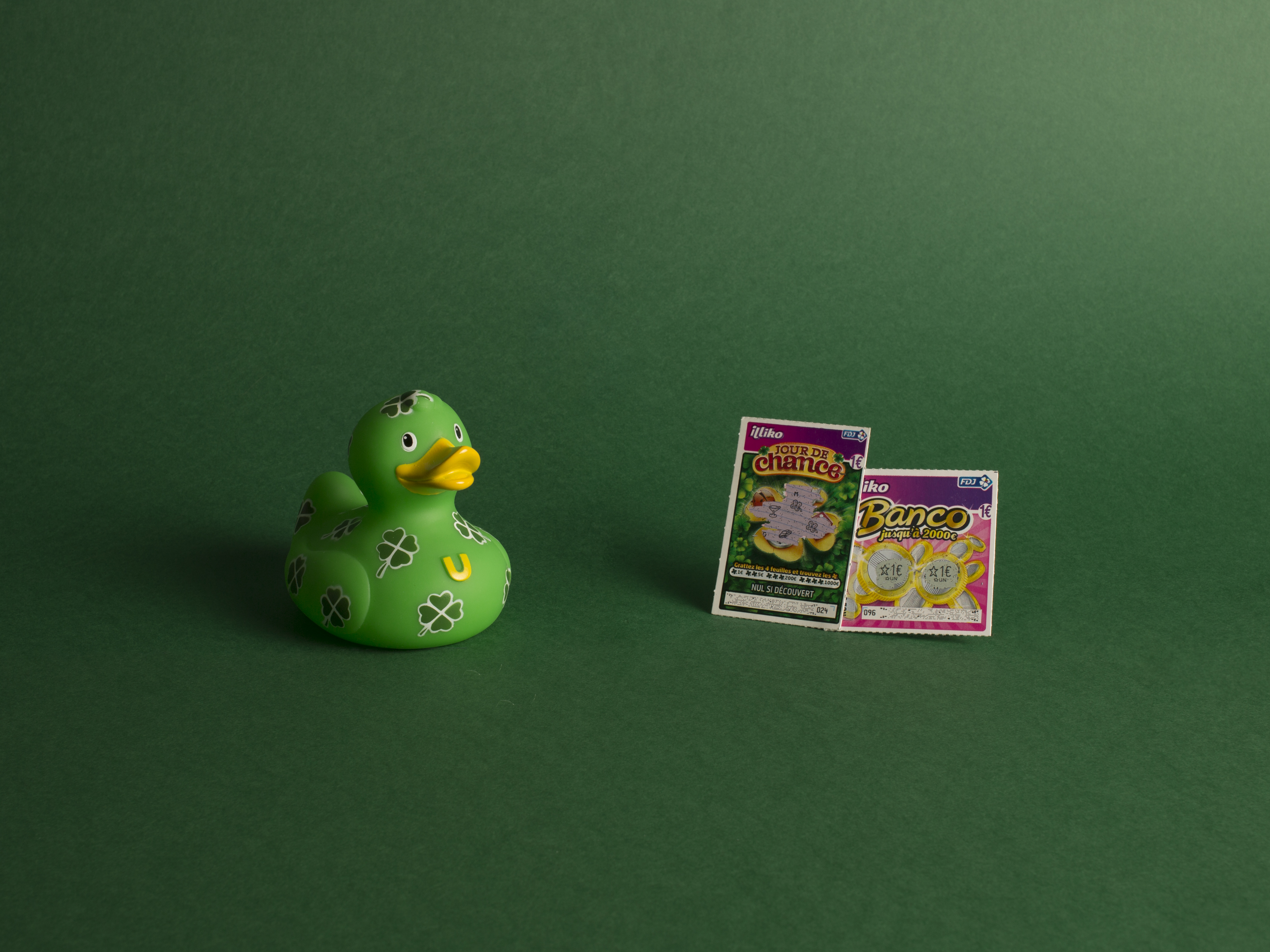 photographie d'un canard en plastique vert à trèfles avec des jeux à gratter