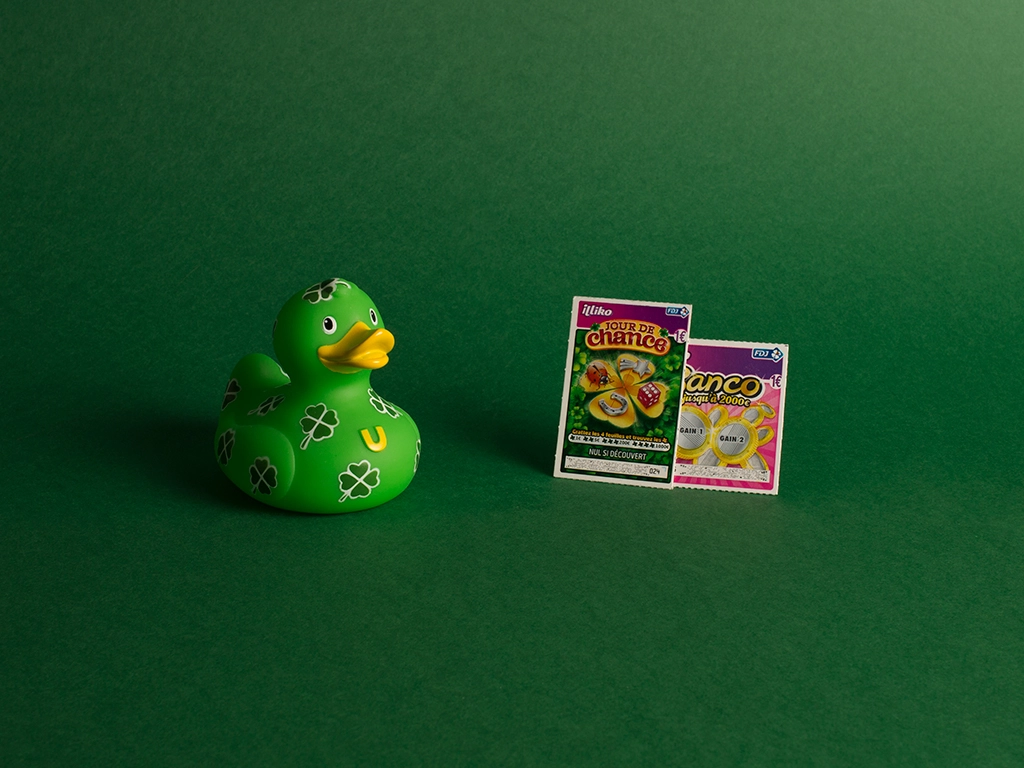 Canard en plastique vert à trèfle avec un jeu à grattage sur fond vert