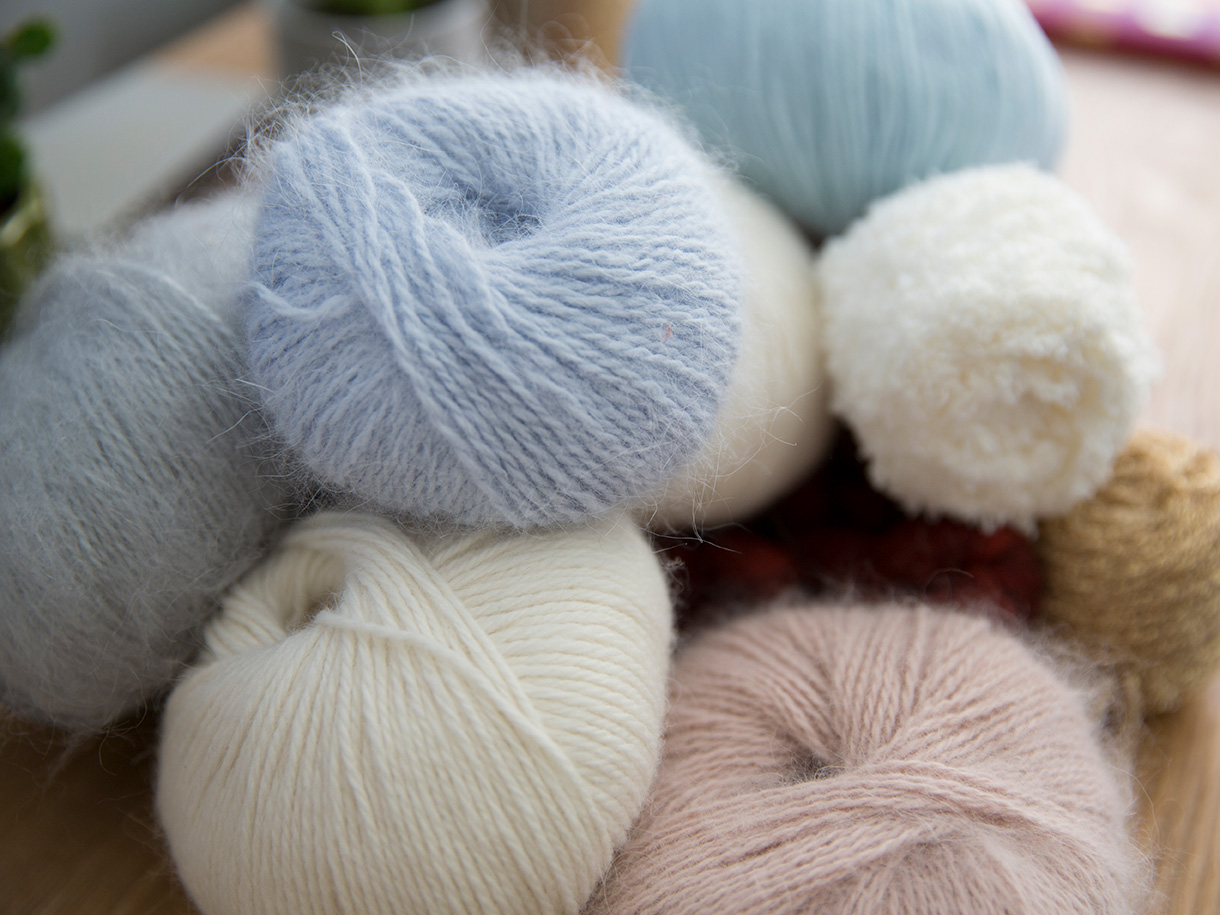 Photographie de pelote de laine écru, bleu ciel et rose